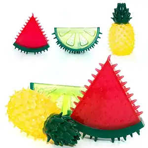 Bunte, stachelige Kauspielzeuge für Hunde: in Form einer roten Wassermelone, einer gelben Ananas und einer grünen Zitrone.