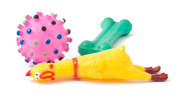 Three colorful rubber dog toys on a white background.