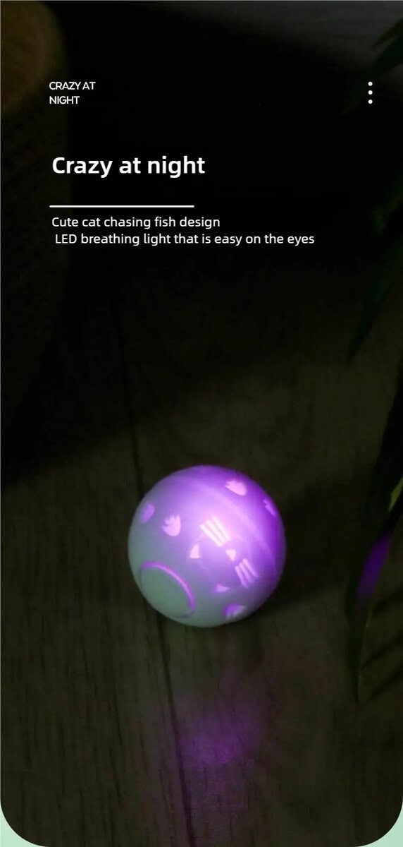 Παιχνίδι LED με μπάλα για γάτες με σχέδια γάτας και ψαριού που λάμπει μωβ σε σκούρα δάπεδα. Απαλό φως LED, ιδανικό για παιχνιδιάρικες γάτες.