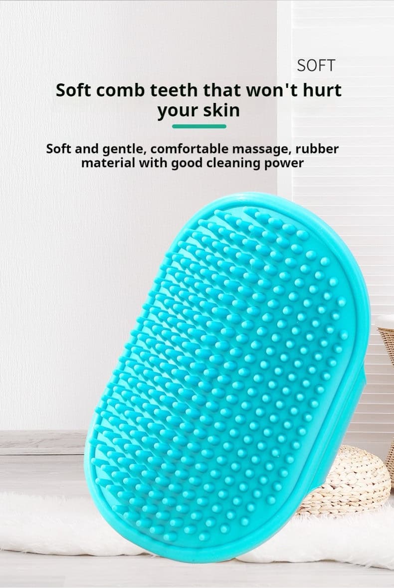 Blue rubber pet bath brush with soft rounded bristles stands upright on a light surface in a plain indoor setting.