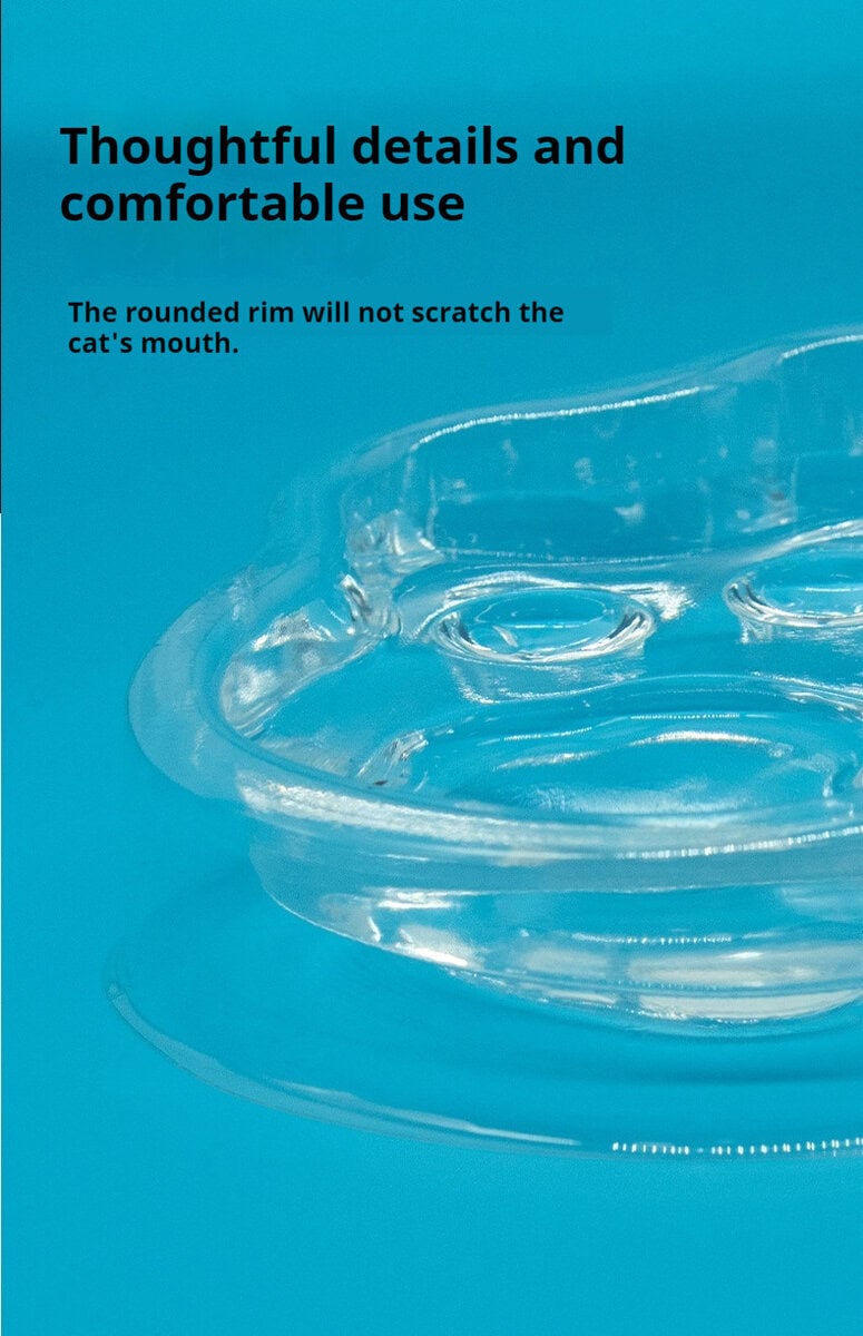 Close-up of transparent cat paw-shaped double food bowl on blue, with text about its comfy rounded rim for cats.