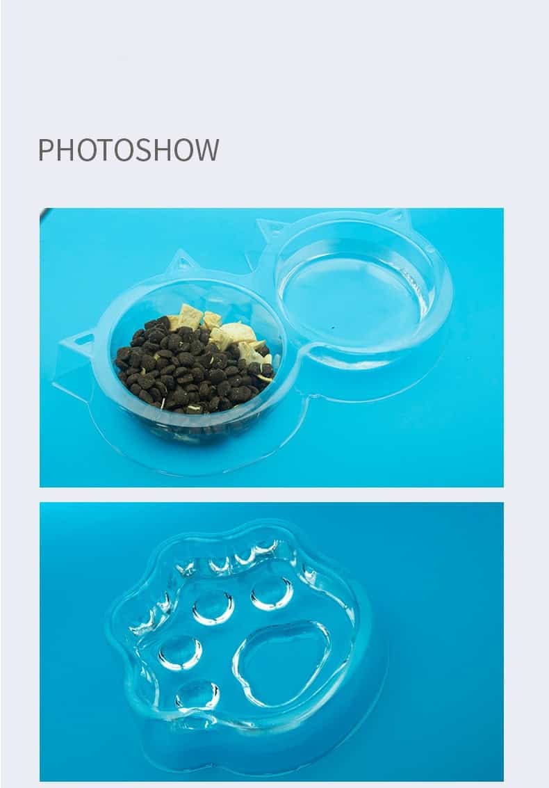Two clear paw-shaped double cat bowls on a blue surface—one with dry food, one empty. Includes a separate paw-print tray.