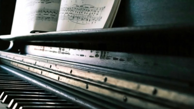 Piano with sheet music, illustrating music therapy for dogs, emphasizing calming melodies.