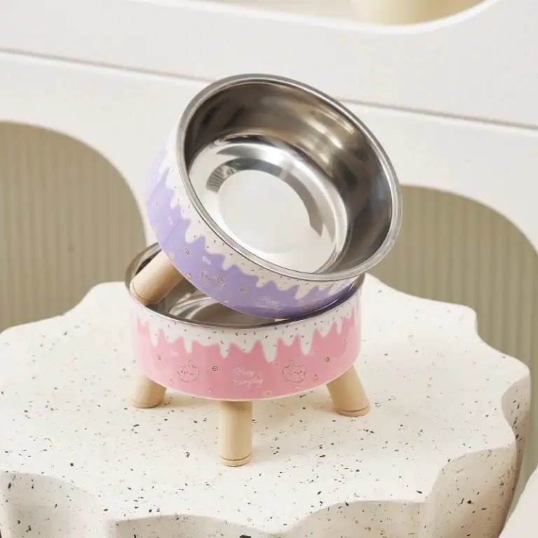 Decorative cat bowl stand with pastel purple and pink colors, featuring a whimsical design and wooden legs, perfect for pet feeding stations.