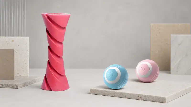 Vibrant pink spiral toy and pastel blue and pink spherical toys on minimalist platforms, showcasing modern design and playful aesthetics.