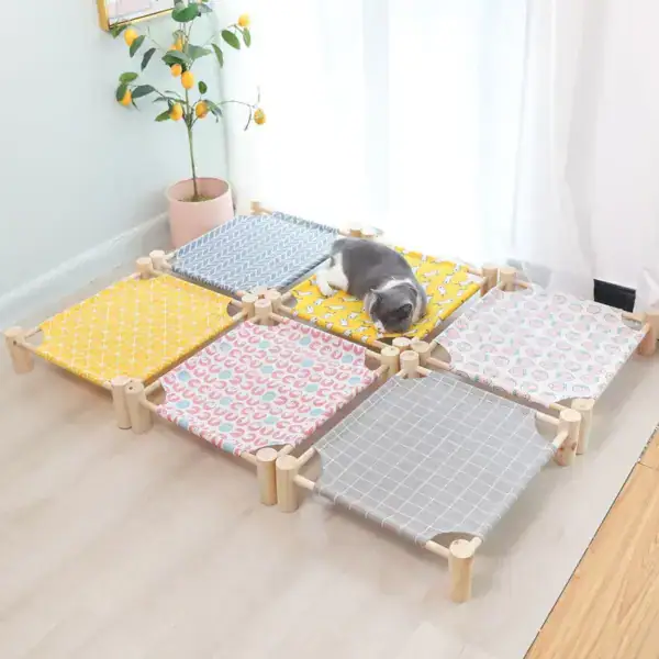 Adorable puppy resting on a multi-colored pet playpen with yellow, blue, pink, and gray fabric panels in a bright room with a potted lemon tree.