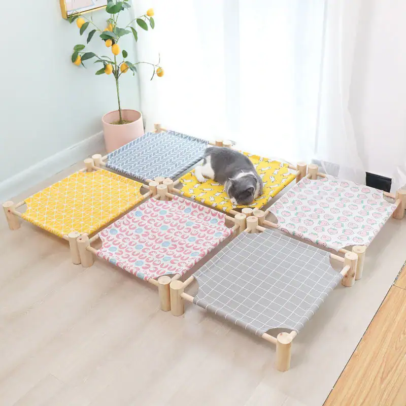 Adorable puppy resting on a multi-colored pet playpen with yellow, blue, pink, and gray fabric panels in a bright room with a potted lemon tree.