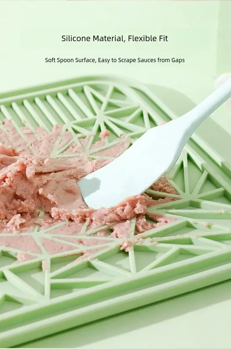 Green silicone food scoop with soft spoon surface for easy scraping and serving from containers.