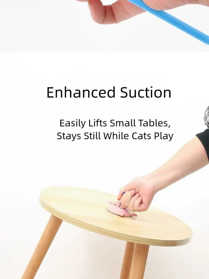 Close-up of a person using a cat toy with enhanced suction to lift small tables, keeping cats entertained while they play.